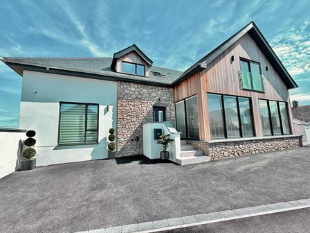 A house with stone wall and large windows at Ardwyn Rhosneigr