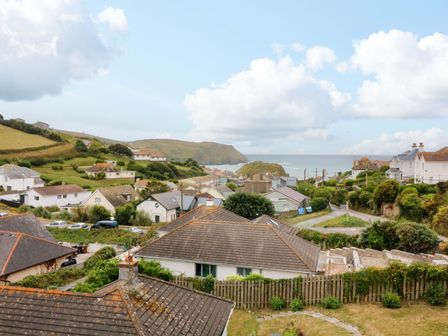 A view of houses and hills with the sea in the background at Surf View in Hope Cove