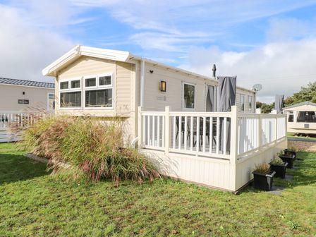 A mobile home with a deck and plants outside Number 34 Foxburrow Hang in Great Yarmouth