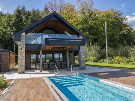 A house with a pool and deck area at Forest Lodge in Pontyclun