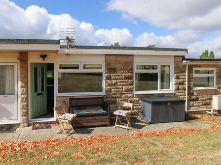 An outdoor area with a bench and chairs at No 157 Sandown Bay Holiday Chalet 'Field View' in Sandown