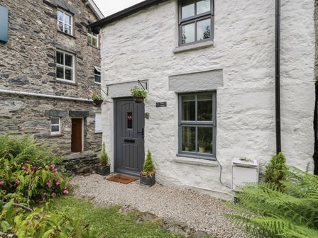 An entrance with a door and window at Squirrel Cottage in Betws-Y-Coed