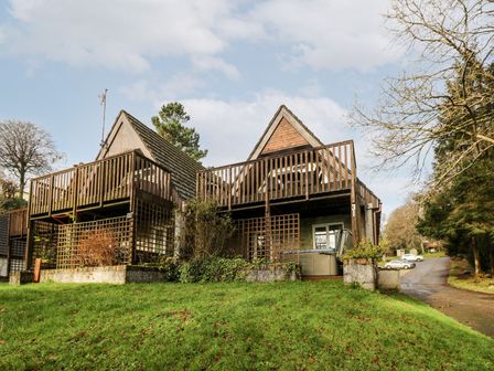 Two adjacent wooden lodges with balconies and a grassy area in front at Valley Lodge 31 in St Ann's Chapel Cornwall