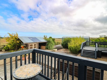 An outdoor area with a balcony and a view of shed and plants at Ava Lodge West Mains near Haggerston