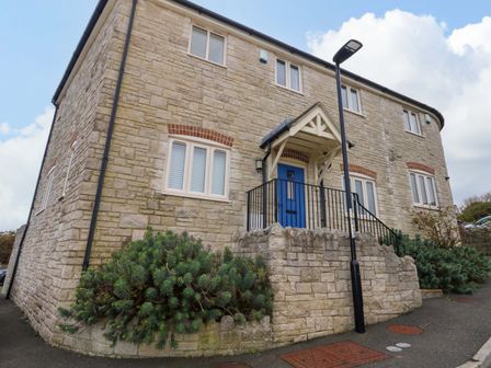 A house with a blue front door and stone exterior at Corner Cottage Preston