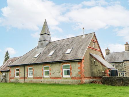 A house with a peaked roof and chimney at Yr Hen Ysgoldy