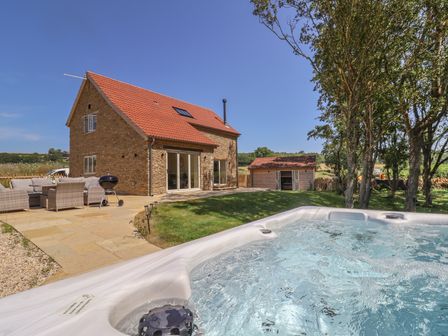 An outdoor area with furniture and a hot tub at The Fox Den in East Coker