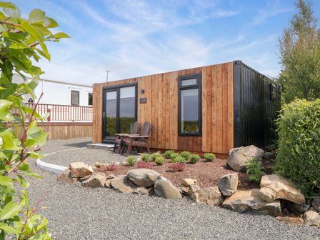 A container home with a garden and seating area at Alken The Hare, Bushmills