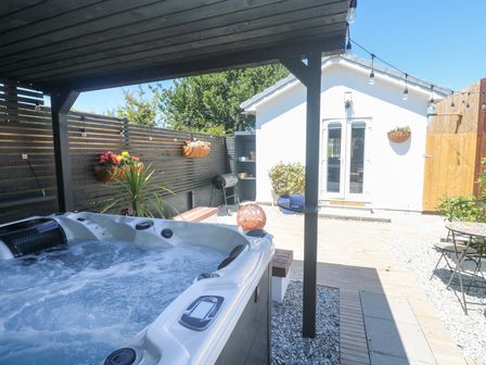 An outdoor area with a hot tub and garden shed at Carn Brea in Redruth