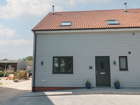 Front view of a house with a door and windows at 1 The Stables Highbridge