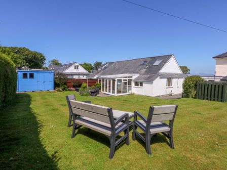 A garden with a patio set and a shed at Swn Y Don