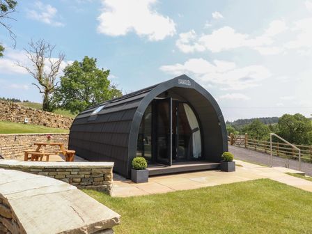 A glamping pod with a table and planter at Barley near Nelson