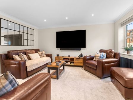 A living room with leather sofas and a television at Hafan Rhos in Rhos-On-Sea