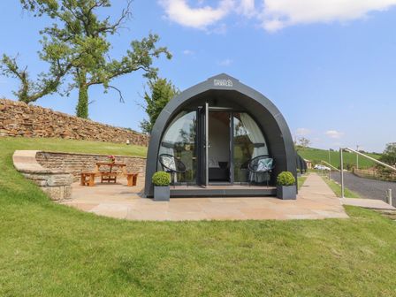 A glamping pod with outdoor seating at Pendle in Nelson