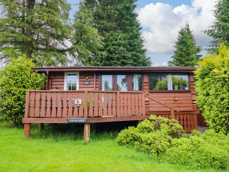 A brown cabin with deck and windows at Swn Yr Afon - No 333 