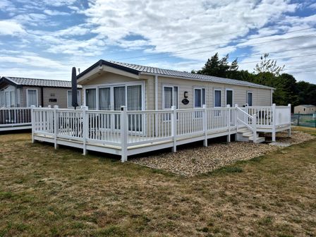 A holiday home with a deck and steps at Fernwood Lodge in Fritton near Belton, Norfolk