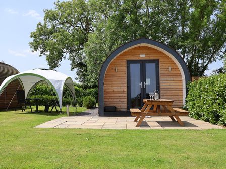 An outdoor area with a pod and seating at Honeypot Hideaways - Manuka