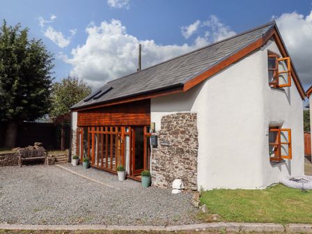 An exterior view of a house with a garden at Church Barn in Sutcombe near Bradworthy