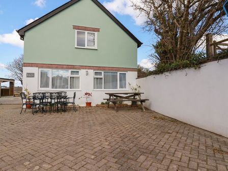 A house with a table and chairs in the outdoor area at Five Elements Barn, St Agnes