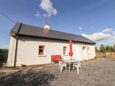 A house with a table and chairs outside at Kate's Cottage in