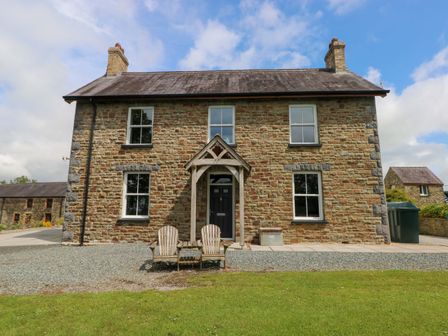 A house with chairs in front at The Sycamores in Llawhaden near Narberth