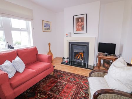 A living room with a sofa and fireplace at Burna in Letterkenny