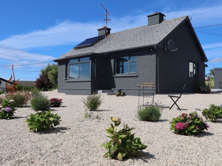 An outdoor view of a house with a garden at The Garden Cottage and Carriage House in Annagry, County Donegal