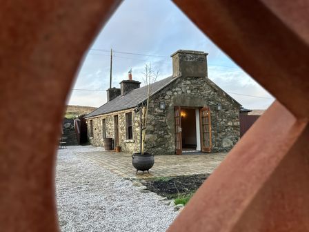 A stone cottage with open doors and gravel path at Cobble Stone Cottage near Leabgarrow, County Donegal