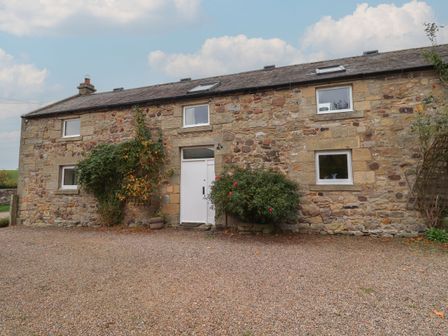 A stone house with a gravel path at Honeymug in Branton near Powburn