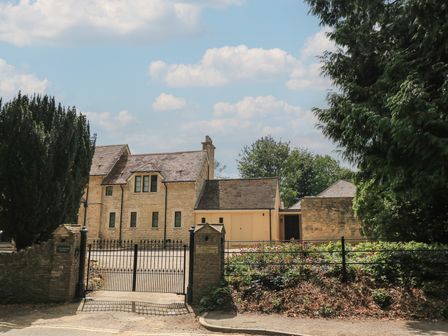 A building with a gate and trees at the Old Cottage Hospital Annexe Burford