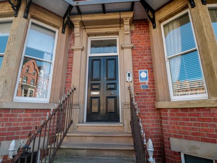 An entrance with a black front door and steps at Stanton House - Abbey View, Flat 3