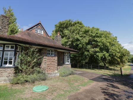 A house with a driveway and trees at Raglan Lodge Monmouth