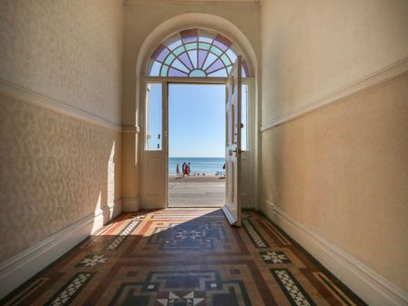 A hallway with door opening to the sea at 123 On The Sea - The Cubby in Weymouth