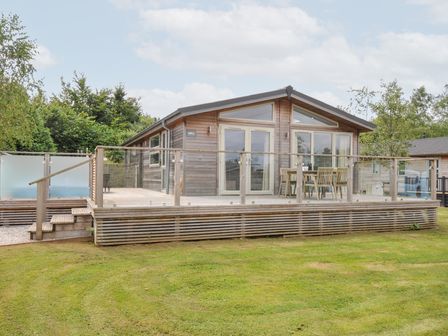 An outdoor area with a wooden cabin and deck at 3 Meadow Retreat in Liskeard