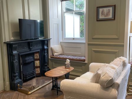 A living room with a fireplace and television at Garden Apartment in Par