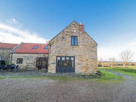 A building with stone exterior and windows at Wheelhouse Cottage in