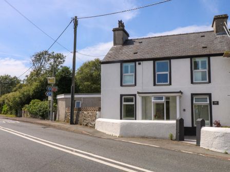 A house with a road and parking sign in front at Cae Gwyn in Ty Croes