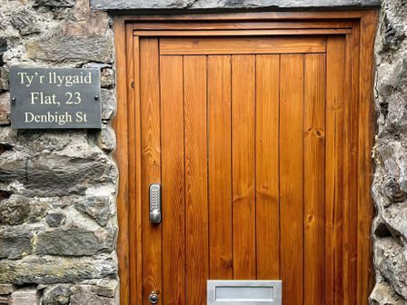 An entryway with a wooden door and a nameplate at Ty'r Illygaid, Denbigh St