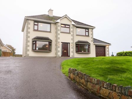 A house with a driveway and garage at Shamrock House 