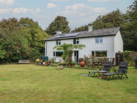 A house with garden furniture and flower pots at Neuadd Wen in Gaerwen