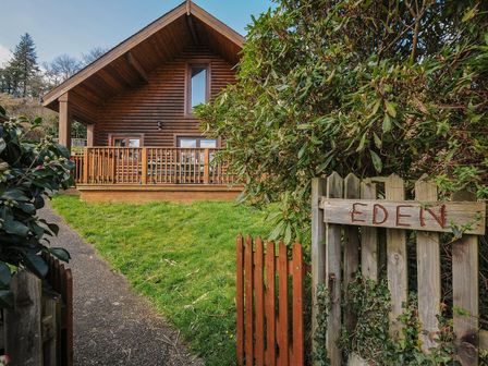 A wooden house with a deck and a sign at Eden in St Breward