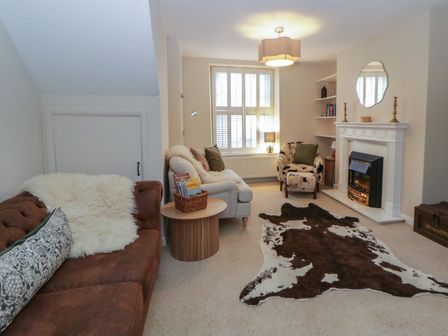 A living room with a sofa and fireplace at Cariad Cottage in Hereford