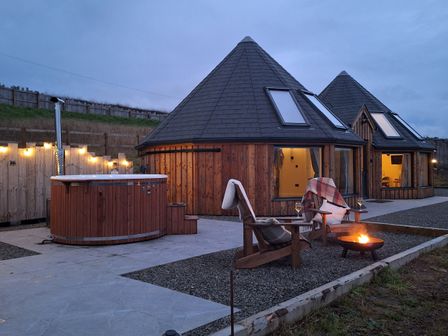 An outdoor area with wooden cabins and a hot tub at Yr Awen - Inspiration near Lampeter