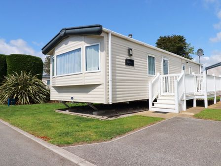 A static caravan with steps and a grassy area at The Oakley in Par