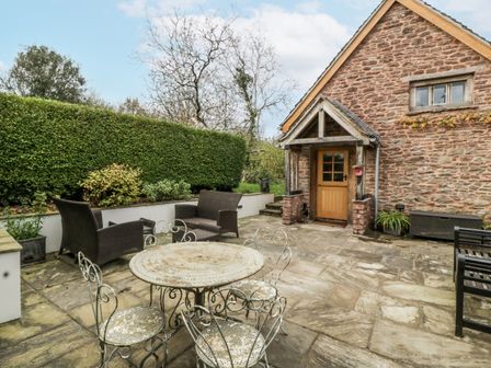 A garden with a stone patio and seating at 1 bed property in Usk