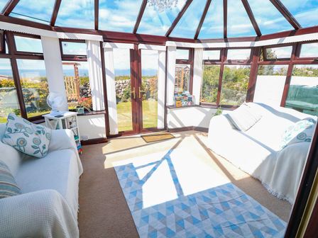 A conservatory with sofas and a rug at Goetra
