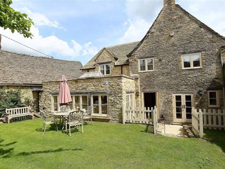 A garden with a table and chairs at The Coach House in Burford