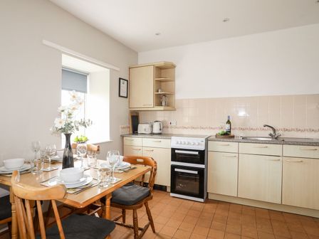A kitchen with a dining table set at Ceiriad - 9 Ty'n Don in Llanengan near Abersoch