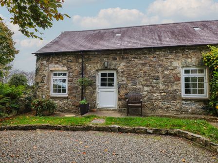 An exterior view of a stone cottage with a front door and windows at Shippen Cottage Clarbeston Road