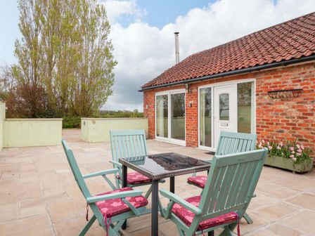 An outdoor patio with a table and chairs at The Owl Barn Cottage